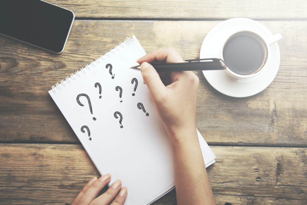 Question marks written on a spiral notebook